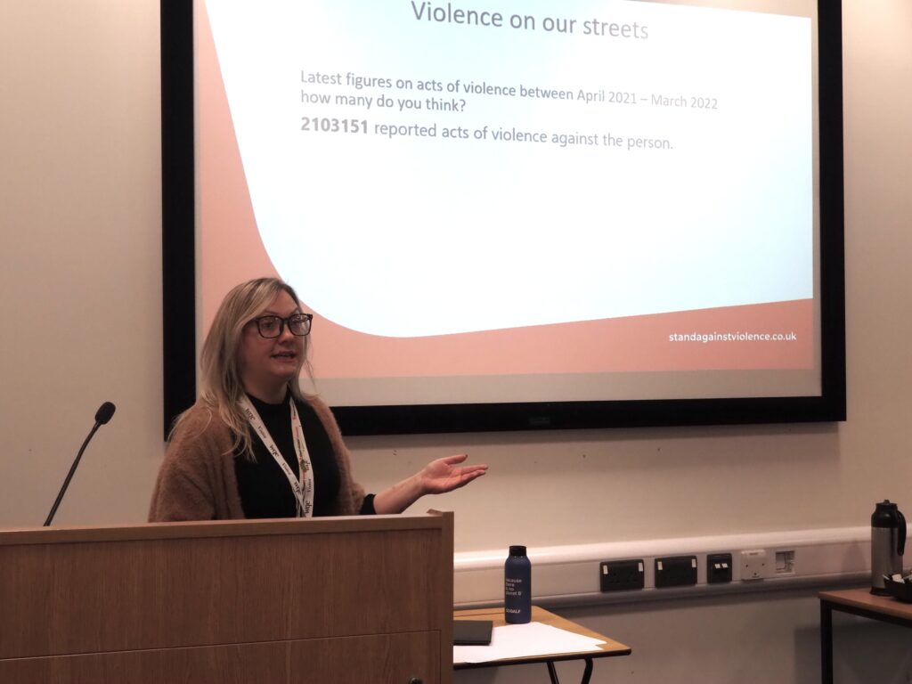 A photo of Bea, from Stand Against Violence, delivering a talk to WQE students.