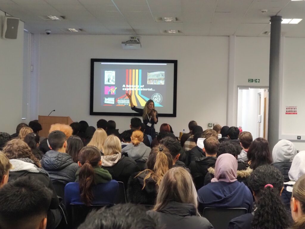 A photo of Libby, from the Sex, Lies and Love Project, delivering a talk to WQE Students